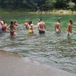 people swimming in waterfall