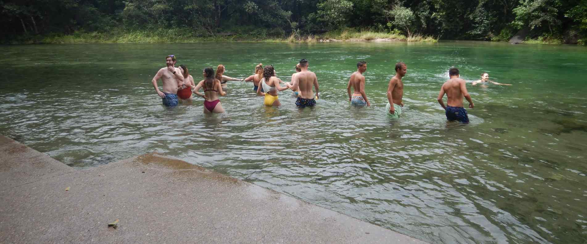 people swimming in waterfall